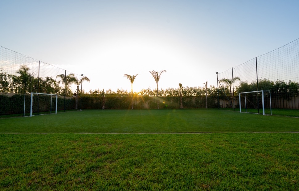 Terrain de football engazonn&eacute; de la Villa Soraya au coucher du soleil